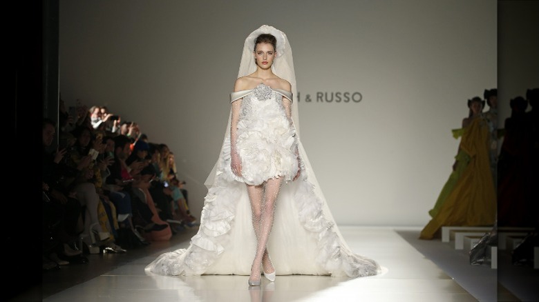 model in wedding dress walking on runway