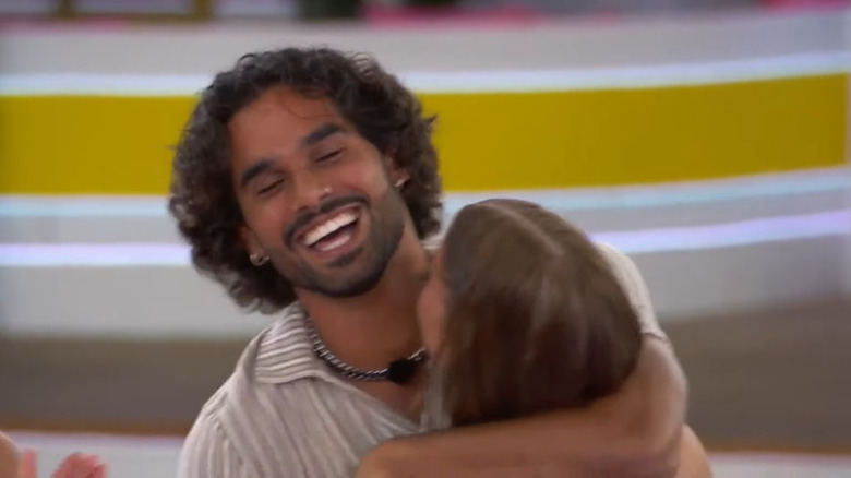 Jared Hassim smiling with Kat Gibson hugging him 