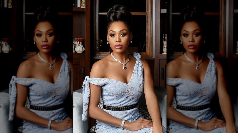 Monique Samuels sitting in powder blue lace dress