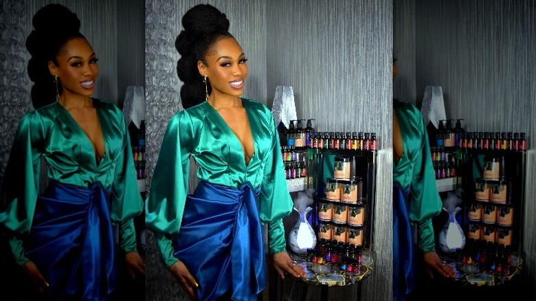 Monique Samuels posing next to her brand's products