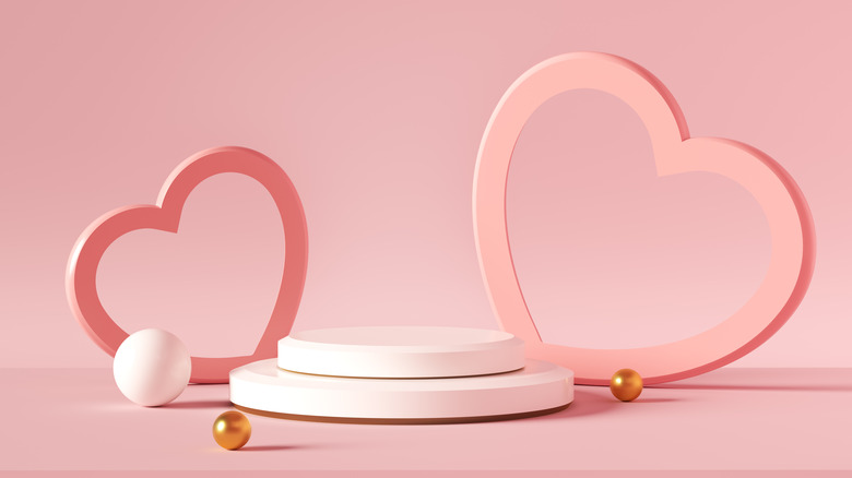 Two heart cutouts against a pink backdrop