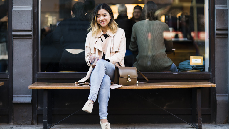 Woman sitting with drink smiling