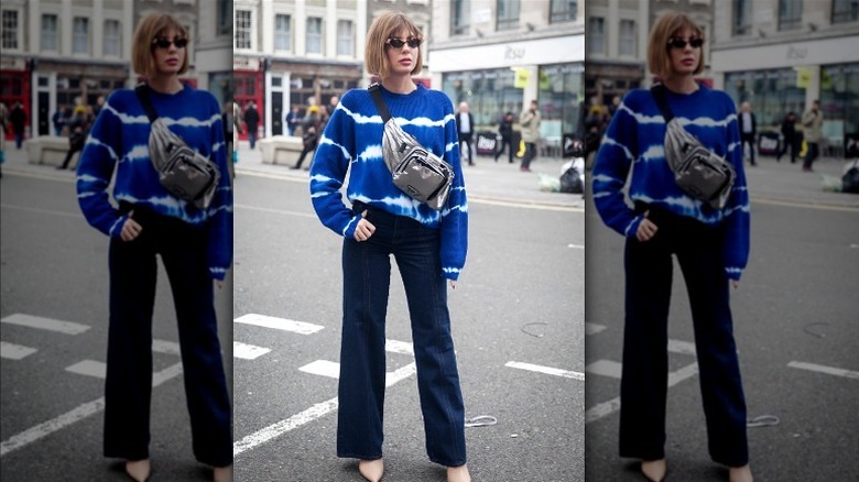 Woman in blue sweater posing on street