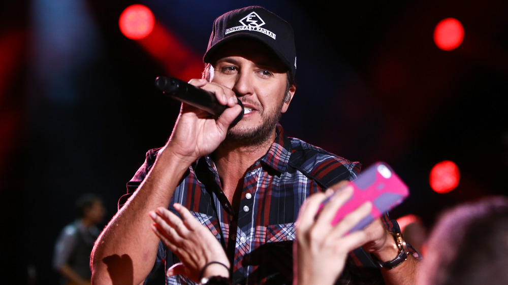 Luke Bryan performing with a hat