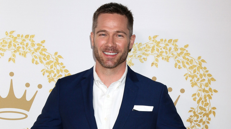 Luke Macfarlane smiling on the red carpet for hallmark