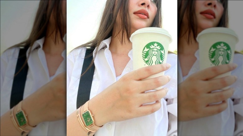 Woman holding starbucks with matching watch