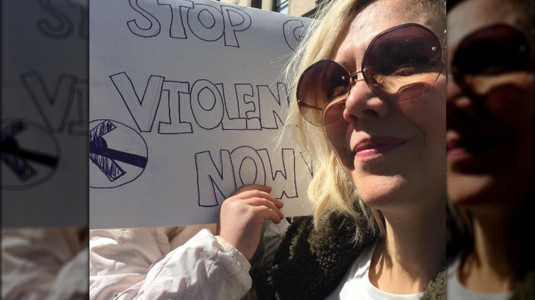 Maggie Gyllenhaal holds daughter, sign