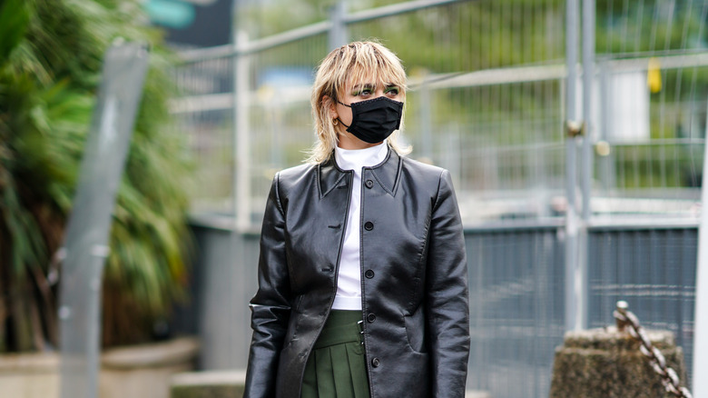 Maisie Williams standing with a masked on