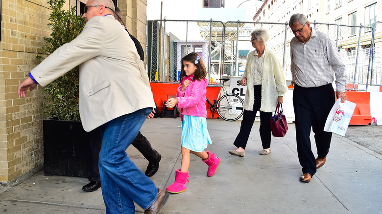 Suri Cruise walking with entourage