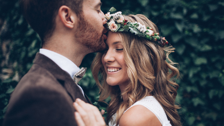 a husband kissing his smiling bride