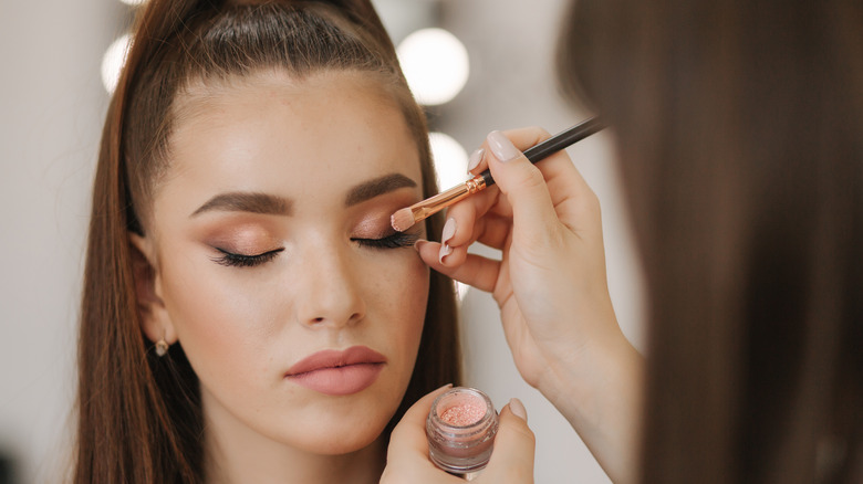 a bride getting a glam smoky eye from her wedding makeup artist