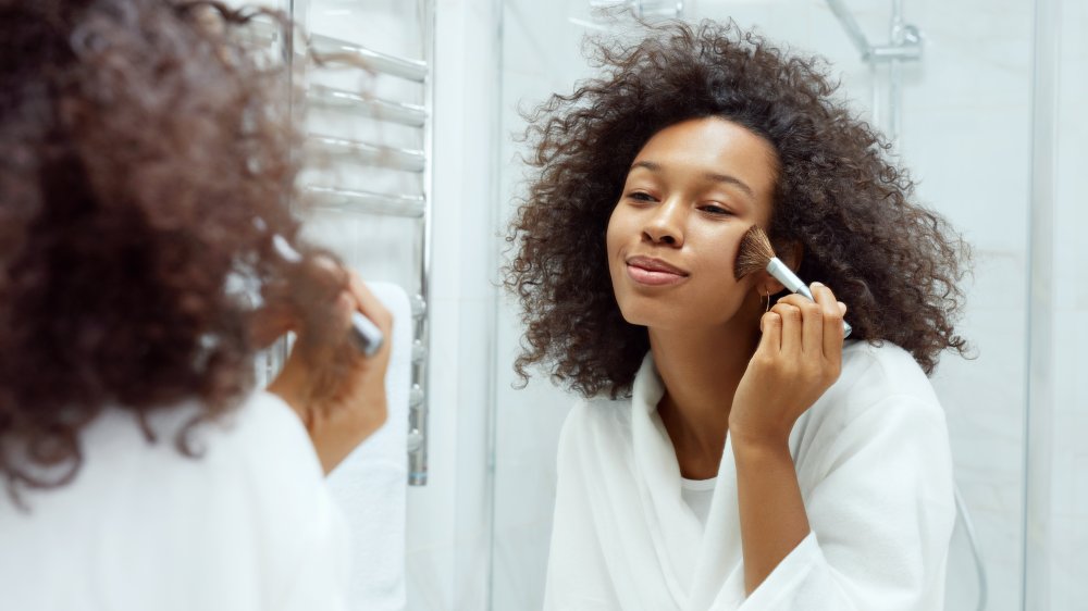 A woman applying foundation with a brush