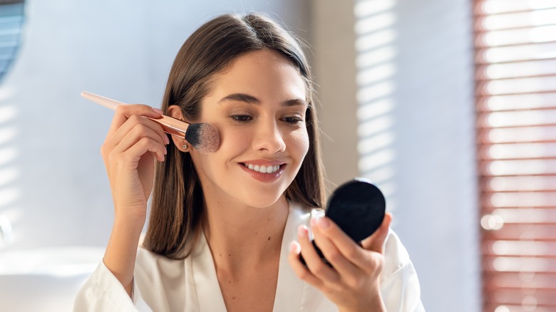 young woman applying makeup