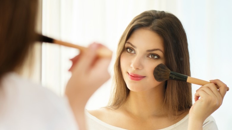 woman applying light makeup