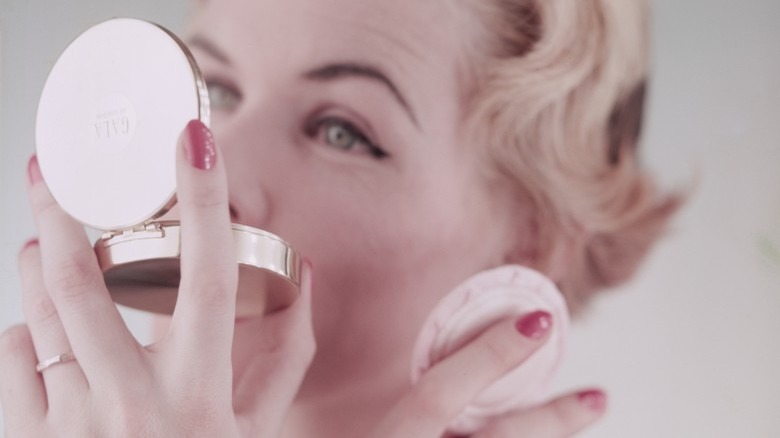 woman applying makeup powder