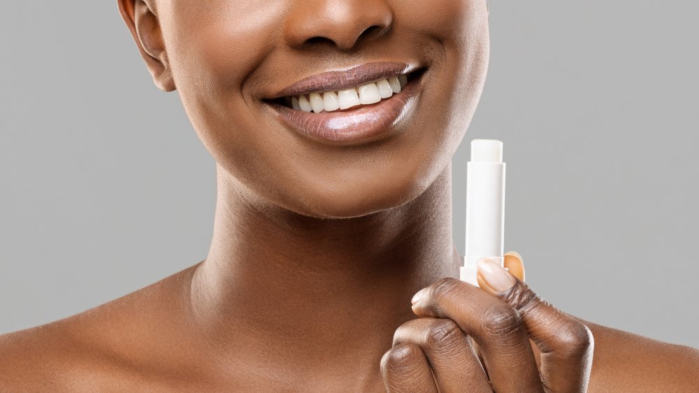 A woman holding chapstick, close-up