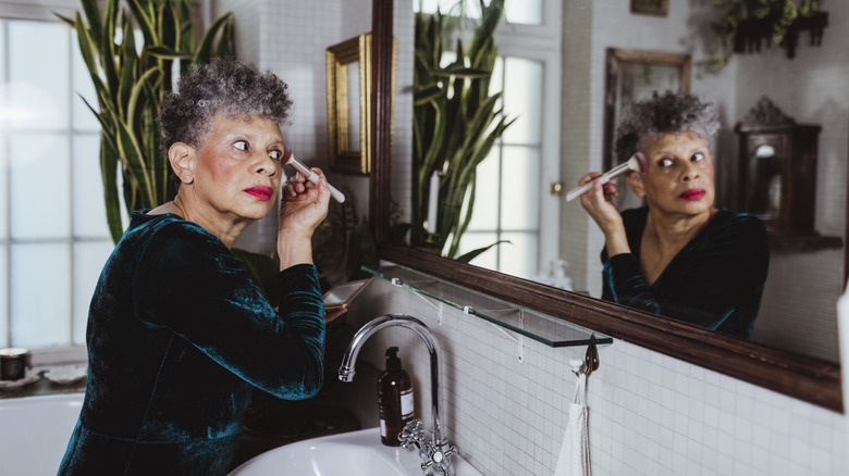 Woman applying blush with makeup brush