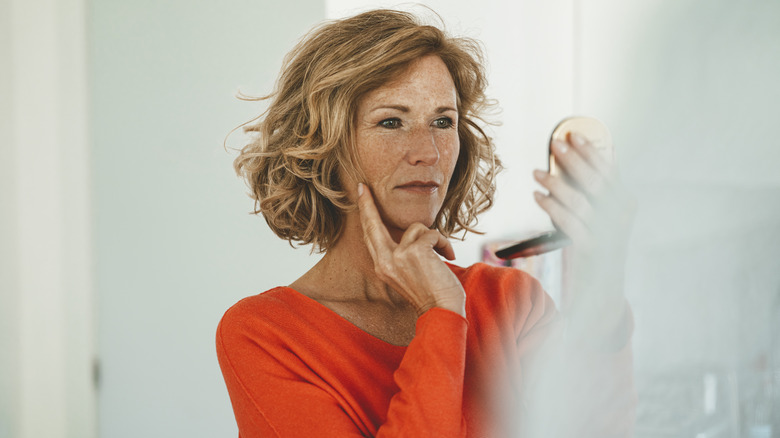 Woman looking in compact mirror