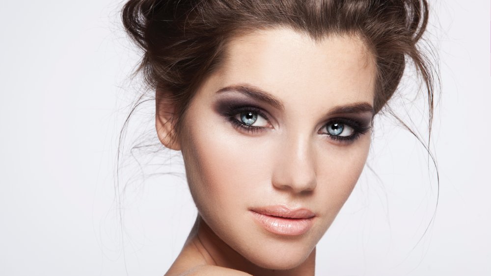 A woman wearing dark black smokey eye makeup trend