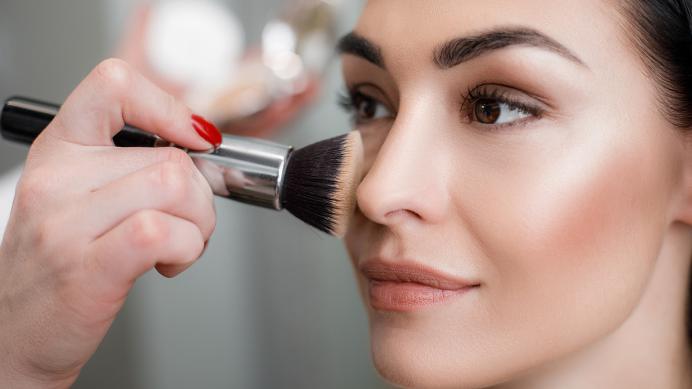 woman applying shimmery makeup