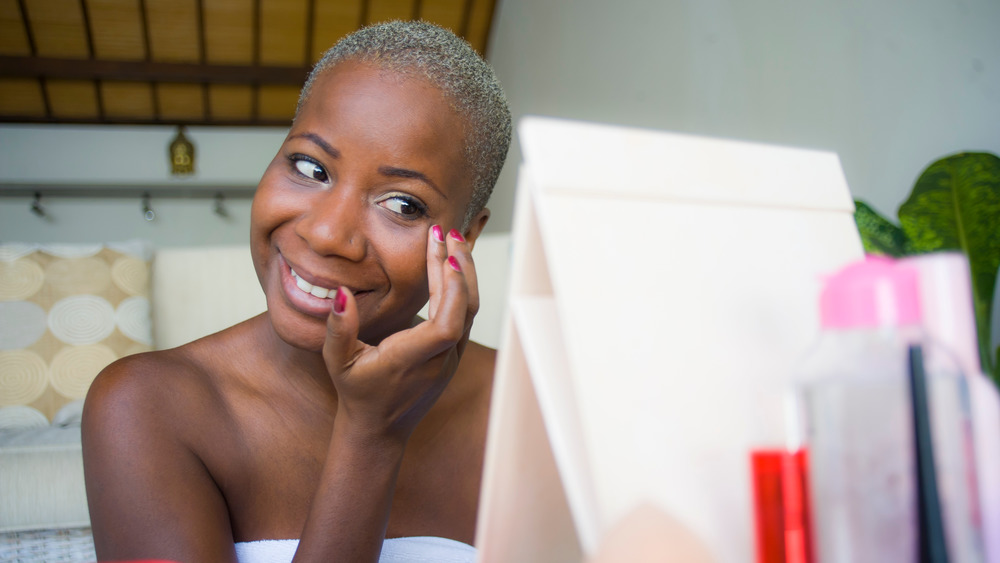 woman applying makeup primer