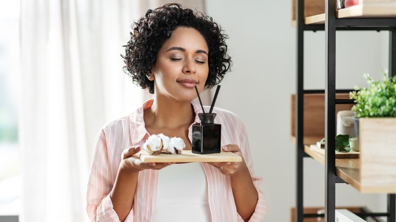 Woman smelling reed diffuser