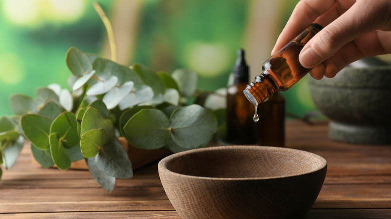 Woman adding essential oil to bowl