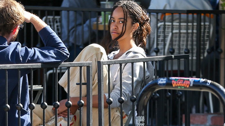 Malia Obama seated outside alone