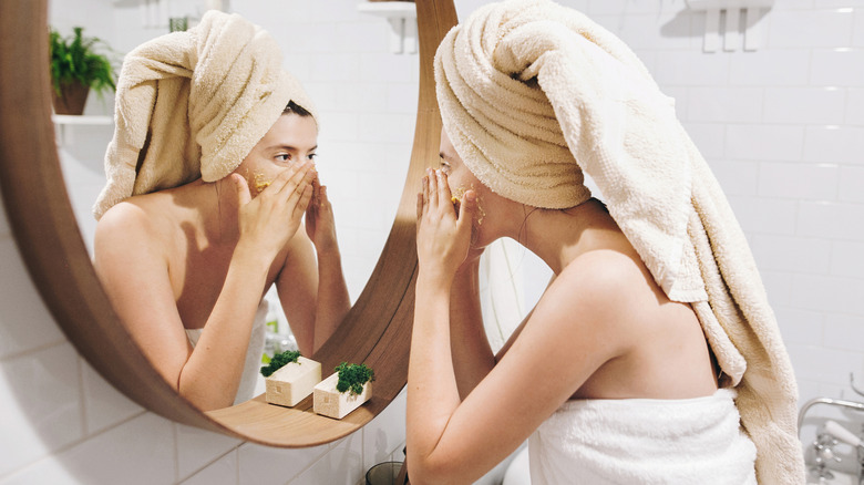 Woman applying cleanser in a mirror