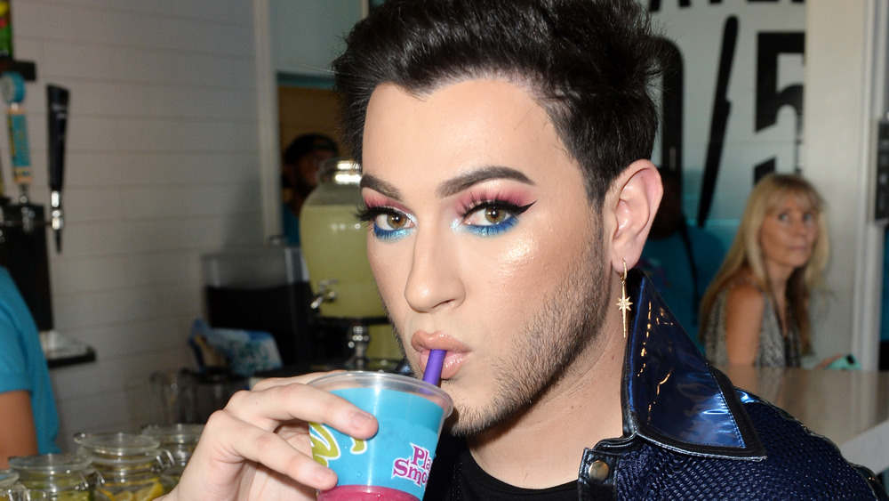 Manny Mua sipping a drink