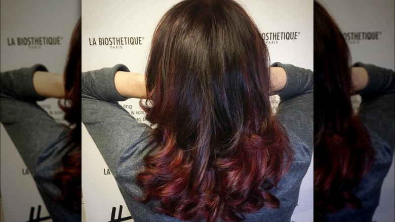 Woman with spiral curls with red marbled hair