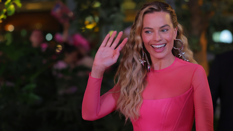 Margot Robbie smiling and waving