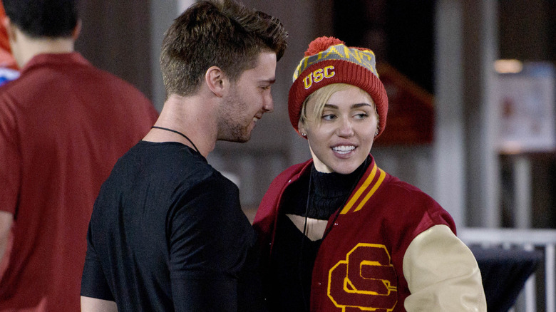 Miley Cyrus and Patrick Schwarzenegger at a game