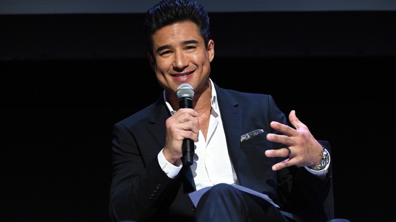 Mario Lopez speaking into a microphone