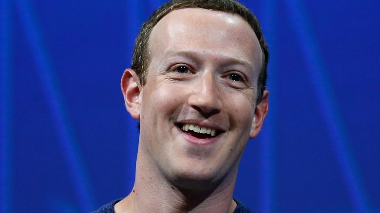 Mark Zuckerberg smiling against a blue background