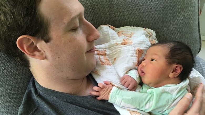 Mark Zuckerberg on a couch, holding an infant