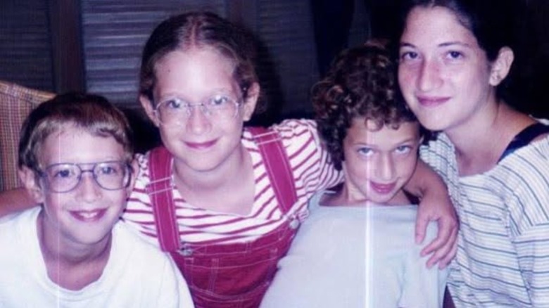 A young Mark Zuckerberg posing with his sisters