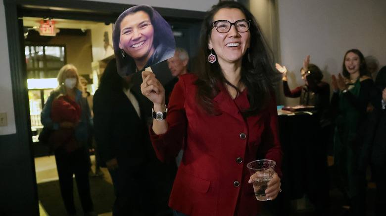 Mary Peltola holding sign with her face