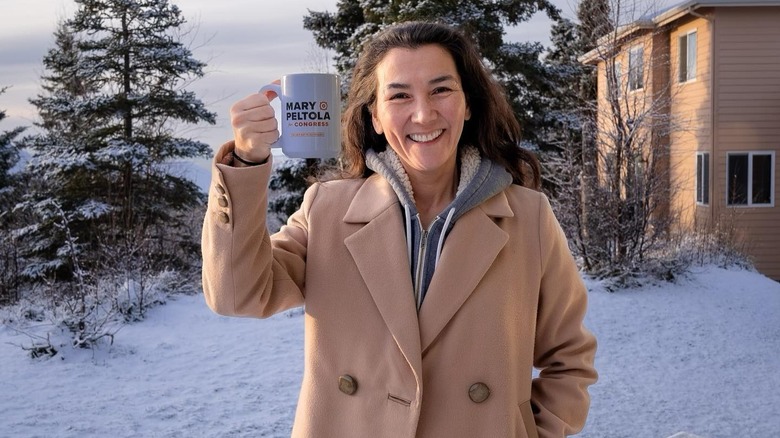 Mary Peltola raising a mug in a toast