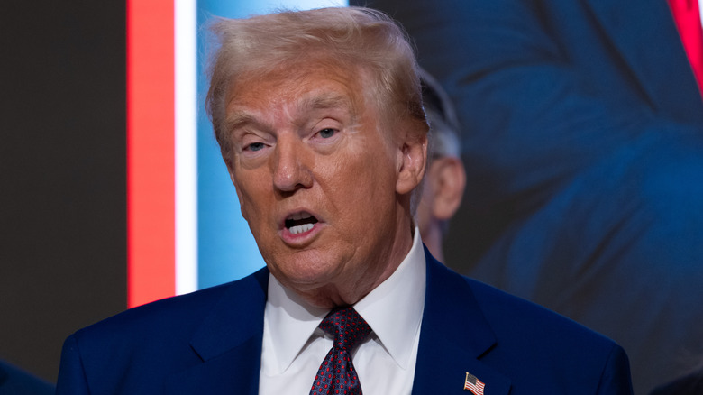 Donald Trump speaking in front of Time magazine cover