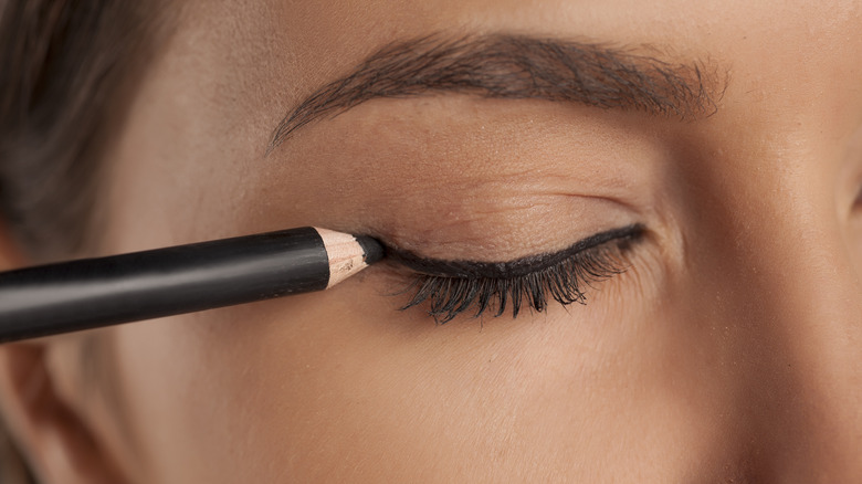 Woman applying eyeliner