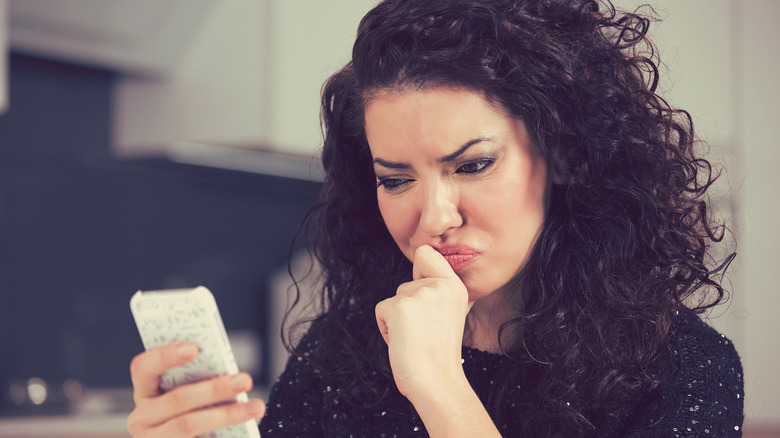 Confused woman looking at phone