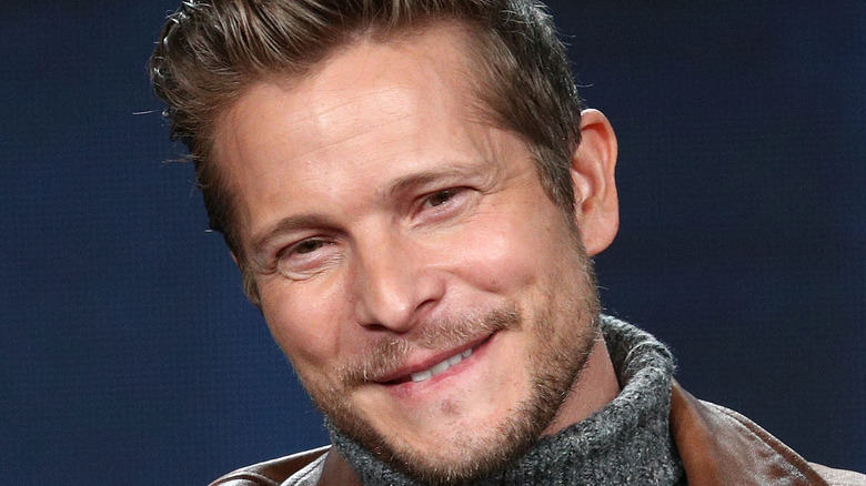 Matt Czuchry smiling onstage at an event