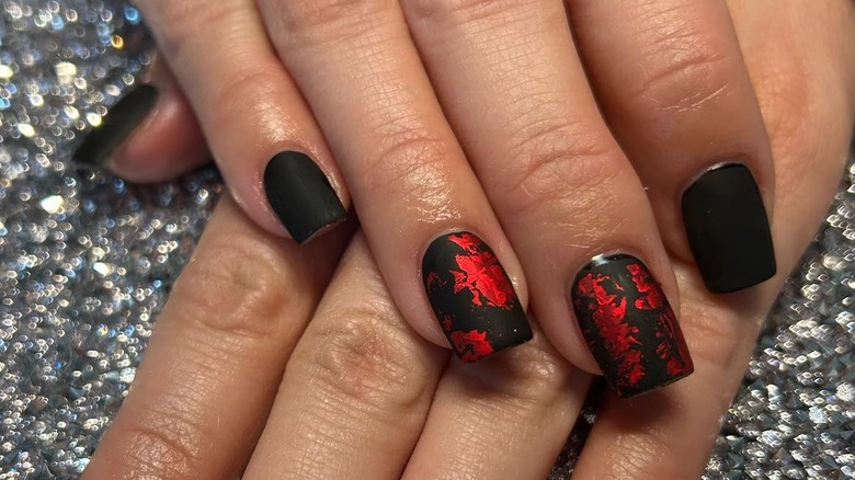 Flat black nails with red flakes