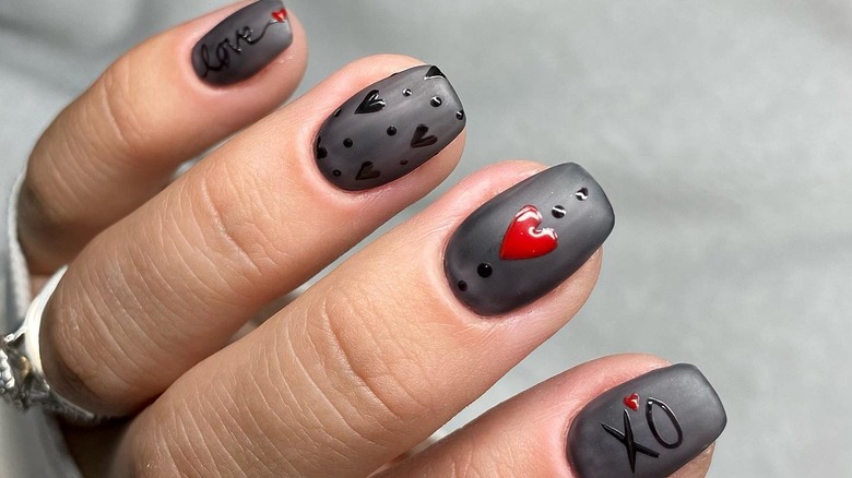 Matte black nails with hearts and flowers