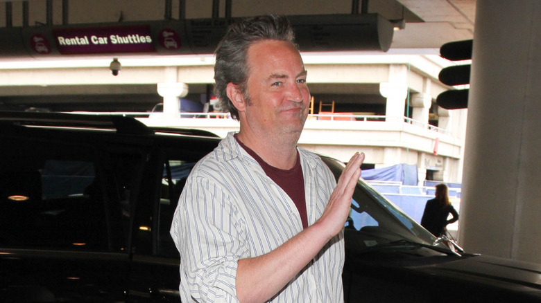 Matthew Perry walks and waves