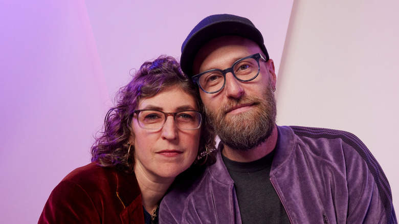 Mayim Bialik and Jonathan Cohen leaning toward each other