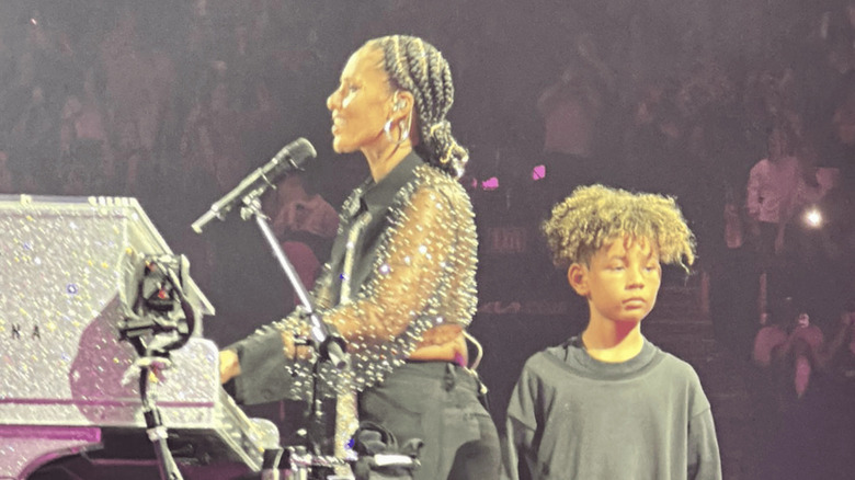 Genesis Dean standing by Alicia Keys on stage