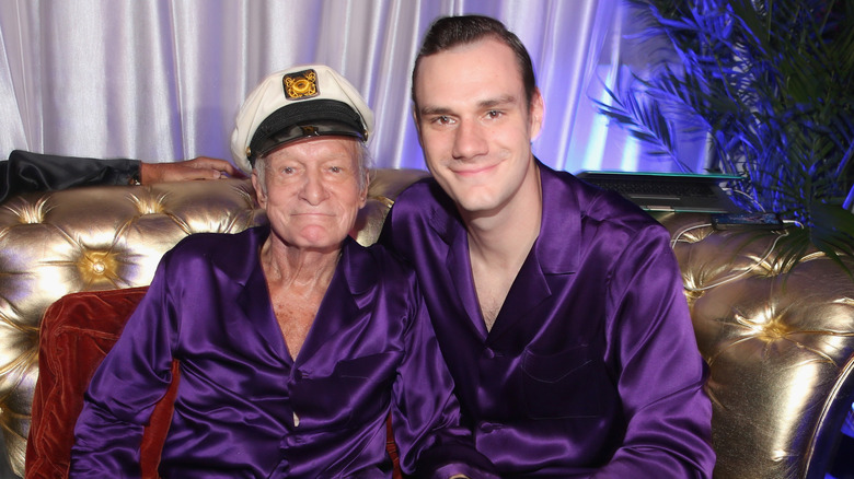 Hugh Hefner and his youngest son Cooper Hefner pose for photos at a Playboy event