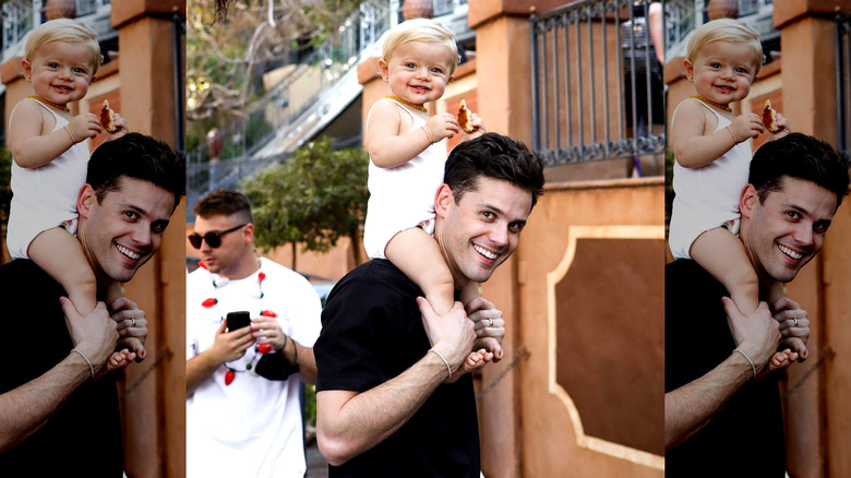 Christopher Osmond smiling while carrying daughter